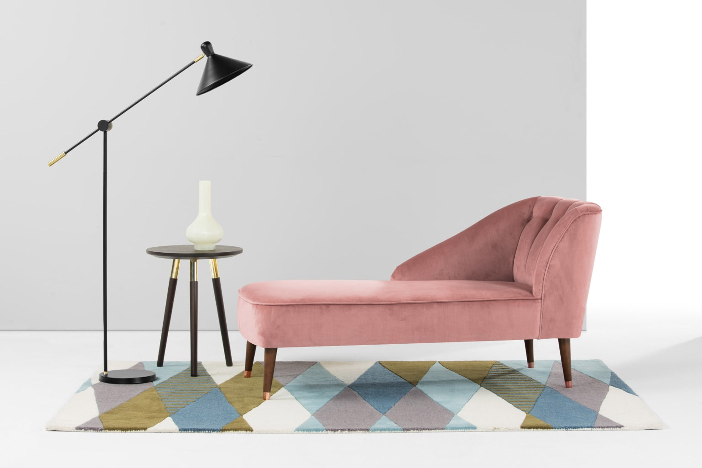 Deep red tufted velvet chaise with sculptural curves and tapered oak legs